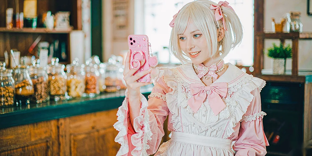 A woman in a cosplay outfit taking a photo of herself